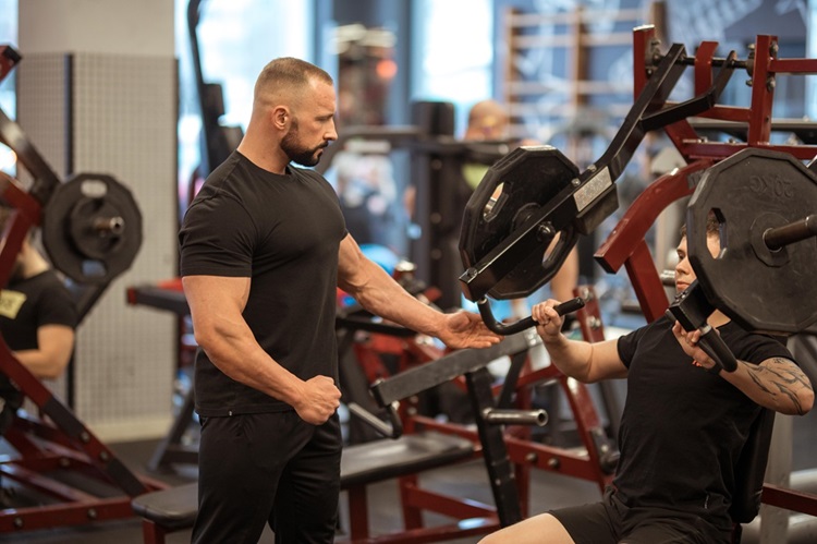 trener personalny prowadzi trening na silowni